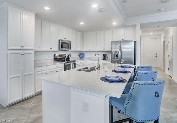 a kitchen with stainless steel appliances granite countertop a sink a stove a refrigerator and cabinets