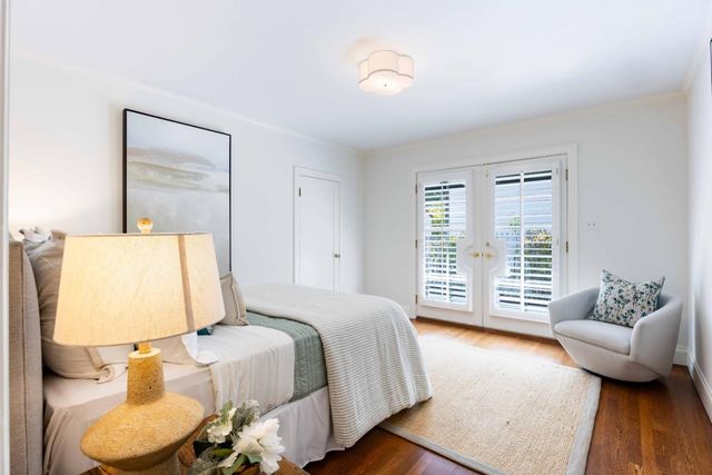 a bedroom with a bed and couch with wooden floor