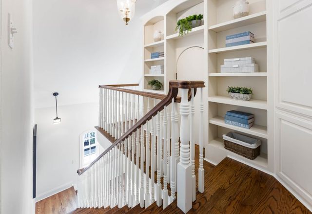 a view of staircase with white walls and wooden floor