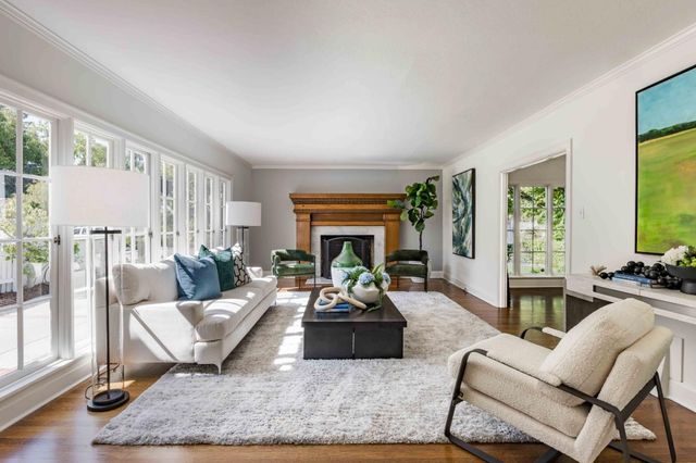 a living room with furniture large window and a fireplace