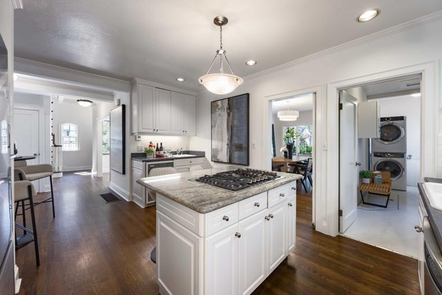 a kitchen with stainless steel appliances granite countertop a stove and a wooden floors