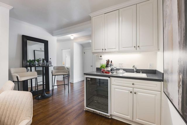 a kitchen with white cabinets and sink