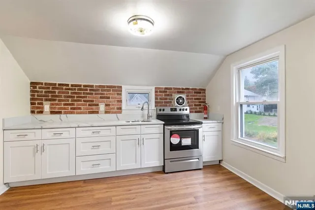 a kitchen with stainless steel appliances granite countertop a stove and a wooden floors