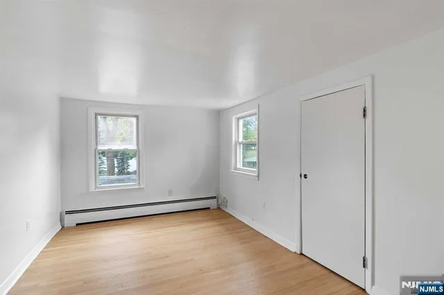 an empty room with windows and closet