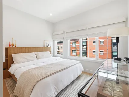 a large bed sitting in a bedroom next to a large window