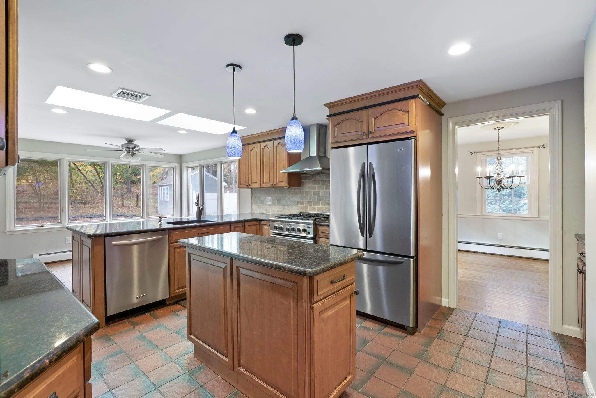 23 Wagon Road Glastonbury, CT 06033 - Photo 14 of 40 a kitchen with stainless steel appliances granite countertop a refrigerator a sink and wooden cabinets