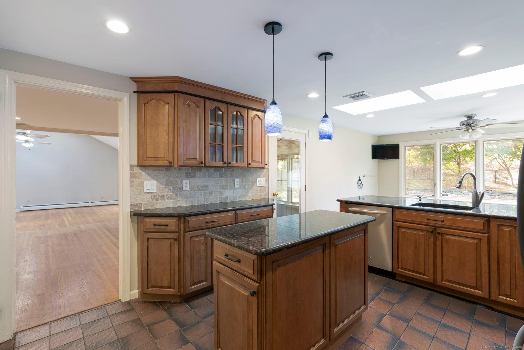 23 Wagon Road Glastonbury, CT 06033 - Photo 15 of 40 a kitchen with kitchen island granite countertop a sink stove and cabinets