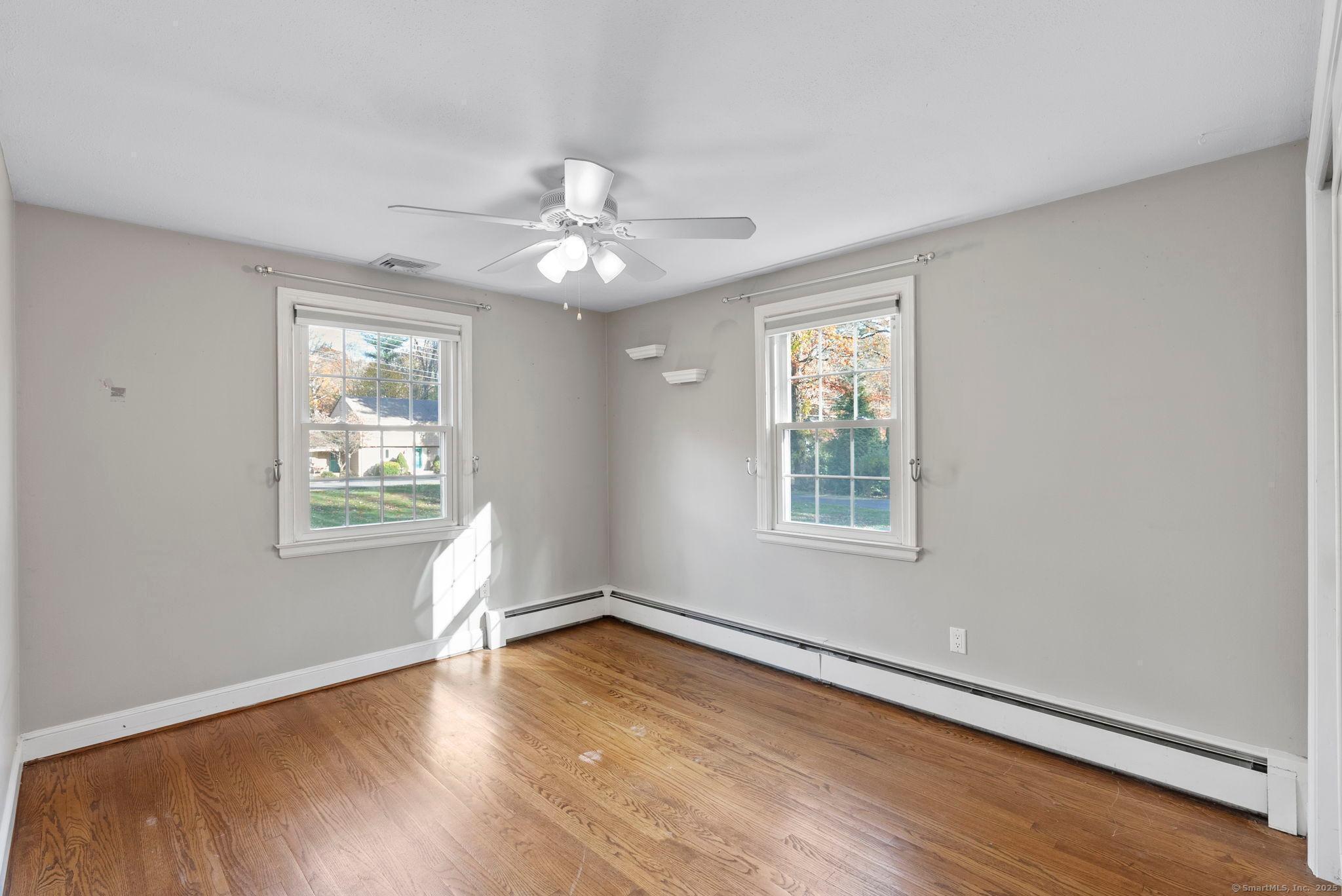 23 Wagon Road Glastonbury, CT 06033 - Photo 23 of 40 a view of an empty room with wooden floor and a window