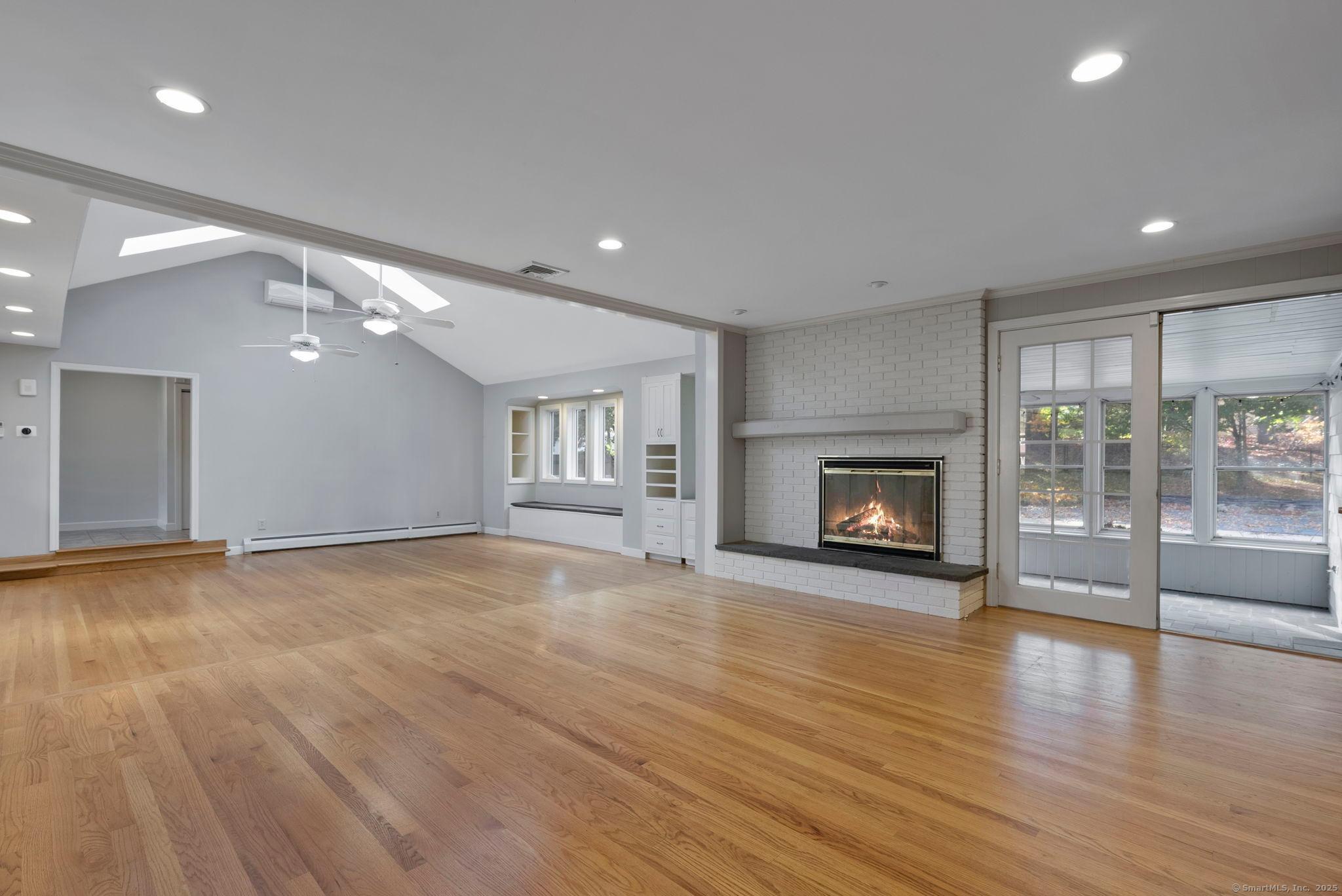 23 Wagon Road Glastonbury, CT 06033 - Photo 7 of 40 an empty room with wooden floor and fireplace