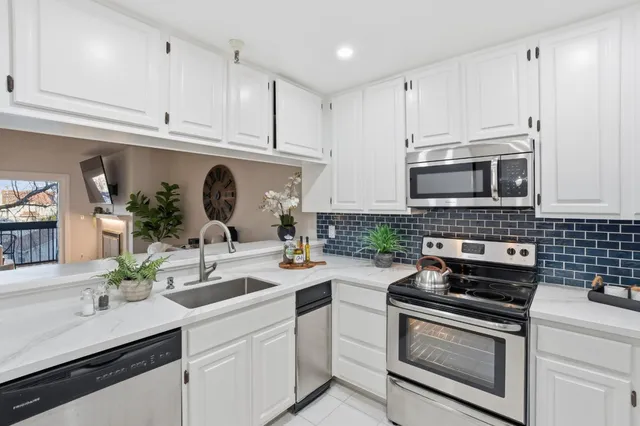 a kitchen with appliances a sink cabinets and a counter top space