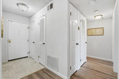 a view of a hallway with wooden floor