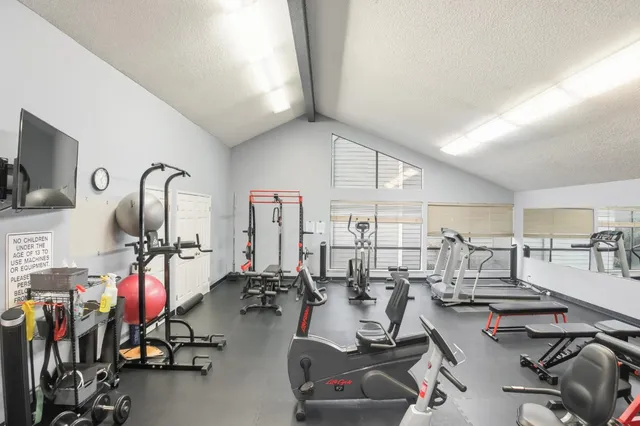 a room with gym equipment and large mirror