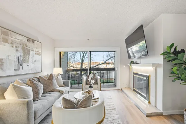 a living room with furniture a flat screen tv and a fireplace