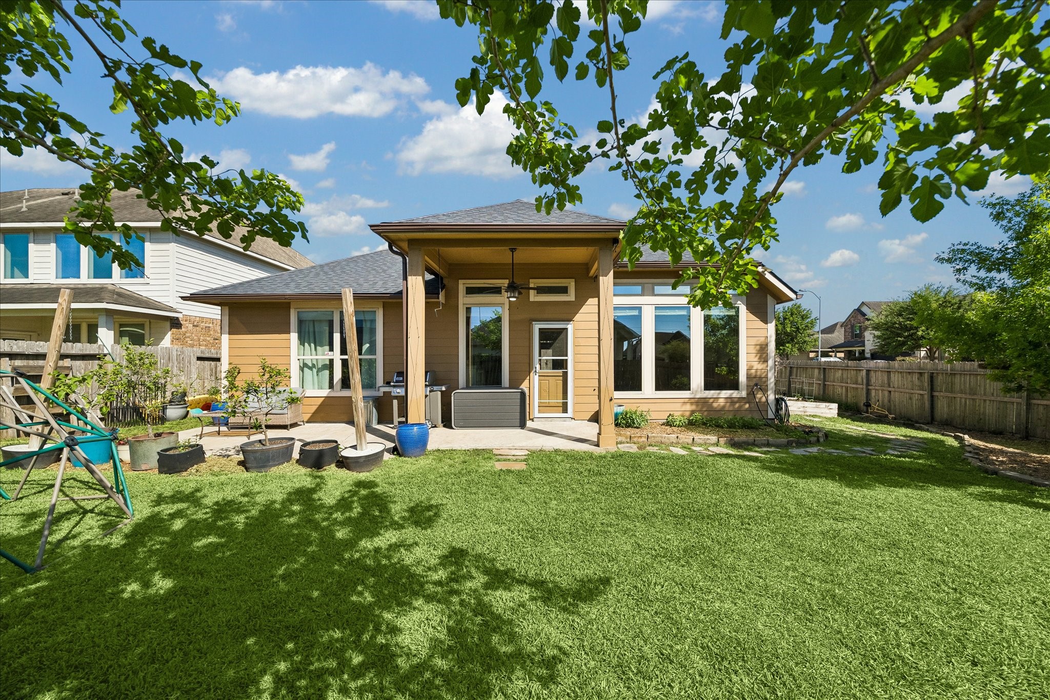 326 Ralston Ranch Court Richmond, TX 77469 - Photo 19 of 28 Fully fenced backyard with a wooden privacy fence, lush green lawn, and a patio area perfect for relaxing or entertaining.