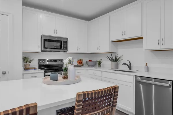 a kitchen with kitchen island white cabinets and stainless steel appliances