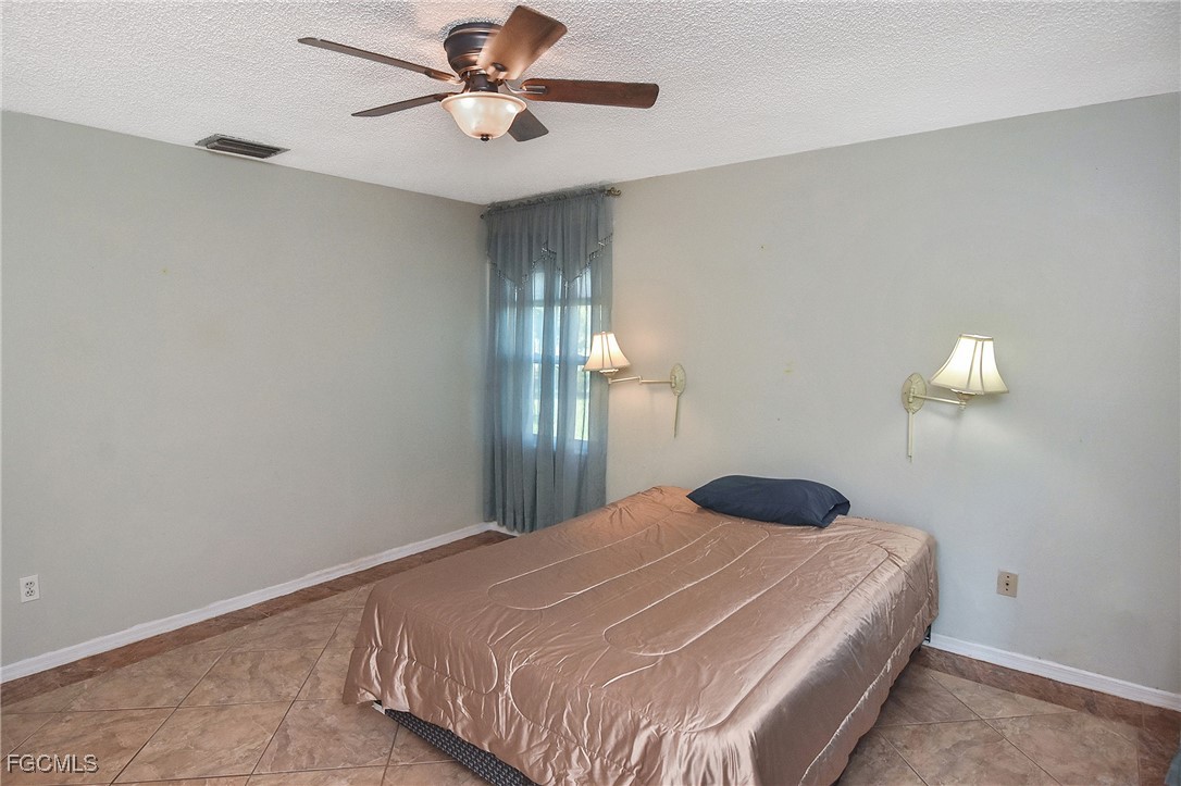 4658 Gulf Shore Road St. James City, FL 33956 - Photo 19 of 50 a bedroom with a bed and a chandelier
