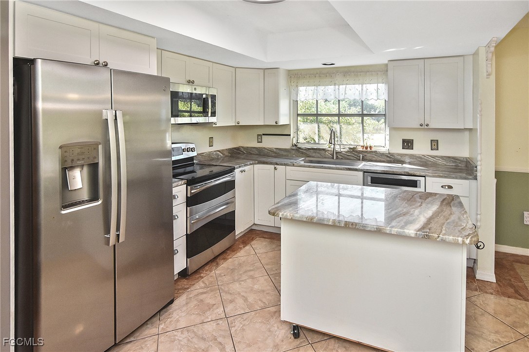 4658 Gulf Shore Road St. James City, FL 33956 - Photo 2 of 50 a kitchen with stainless steel appliances granite countertop a refrigerator a stove a sink and white cabinets