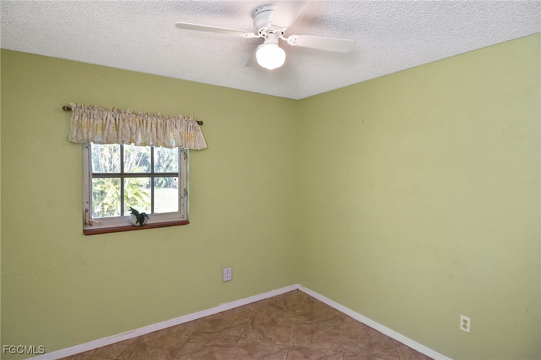 4658 Gulf Shore Road St. James City, FL 33956 - Photo 38 of 50 an empty room with a window and ceiling fan