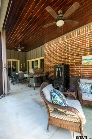 a view of a patio with table and chairs potted plants and large tree