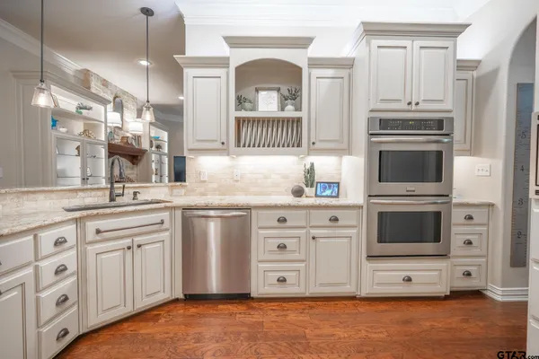 a bedroom with a large bed a flat tv screen and dresser
