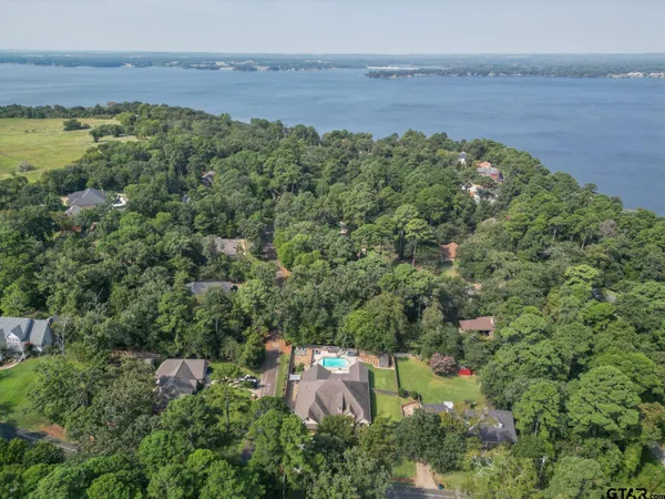 a kitchen with stainless steel appliances granite countertop a table chairs refrigerator and a sink