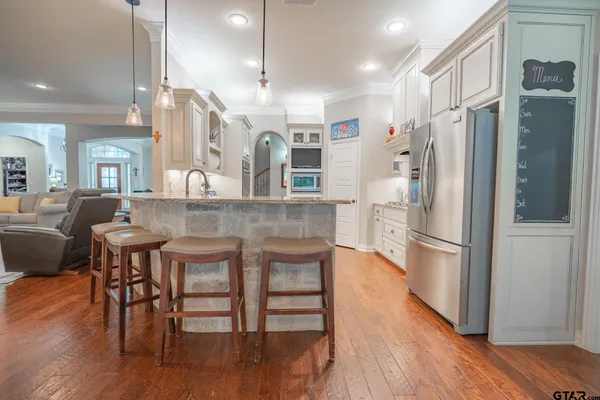 a kitchen with granite countertop a sink cabinets and stainless steel appliances