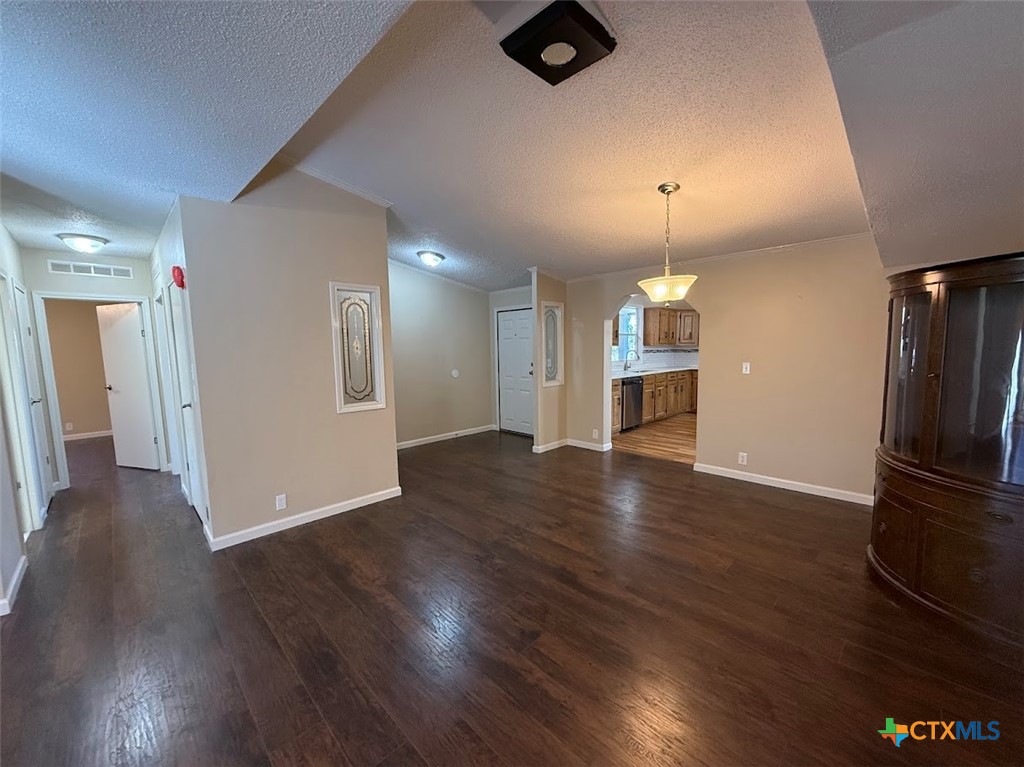4551 Chamberlain Way Canyon Lake, TX 78133 - Photo 11 of 34 an empty room with wooden floor kitchen view and a refrigerator