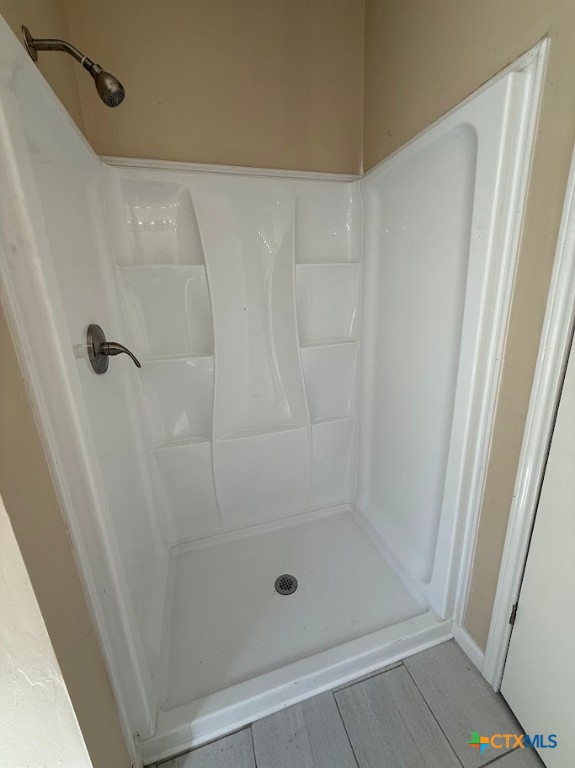 4551 Chamberlain Way Canyon Lake, TX 78133 - Photo 16 of 34 a bathroom with a glass shower door