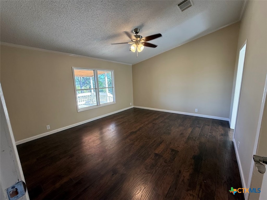 4551 Chamberlain Way Canyon Lake, TX 78133 - Photo 20 of 34 an empty room with wooden floor fan and windows
