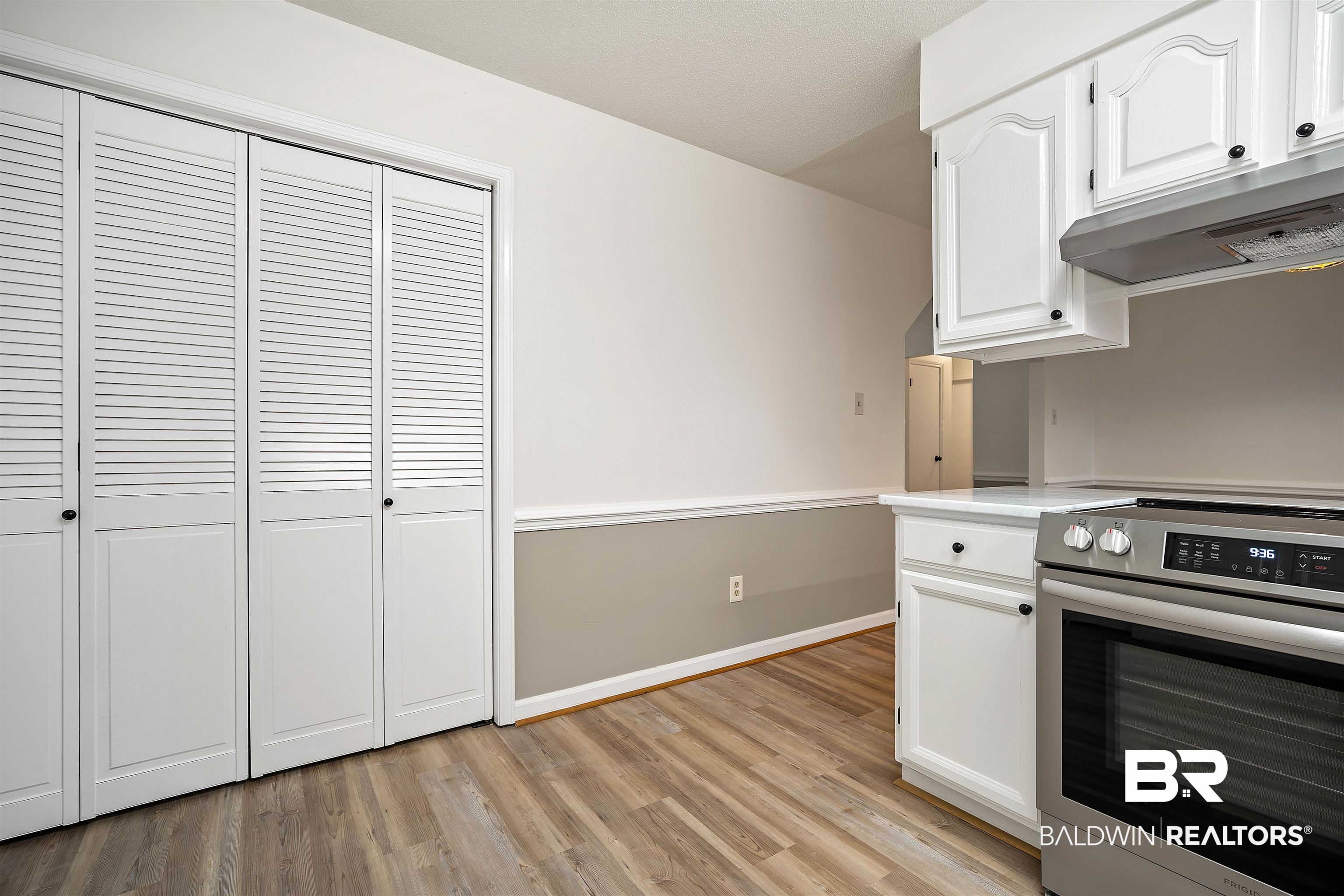 6701 Howells Ferry Road Mobile, AL 36618 - Photo 10 of 25 Kitchen featuring electric stove, white cabinetry, and light hardwood / wood-style floors
