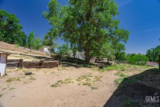 a view of a yard with wooden fence
