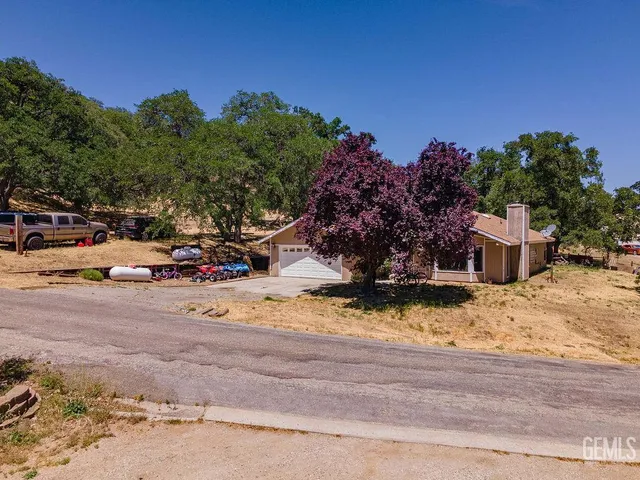 a view of a backyard with a cars parked on the road