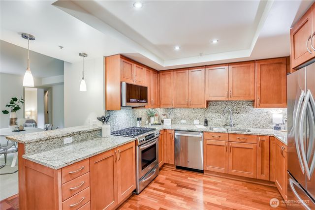 a kitchen with stainless steel appliances granite countertop a sink a refrigerator and a granite counter tops