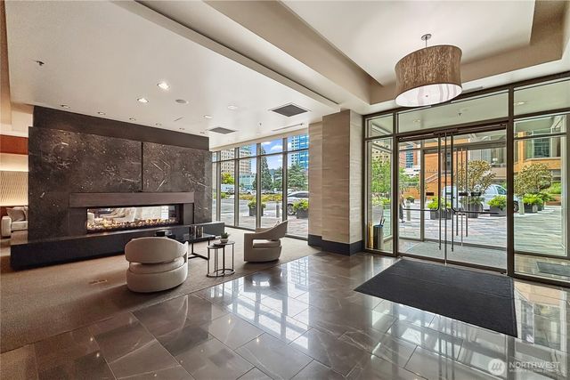 a living room with furniture a fireplace and a floor to ceiling window