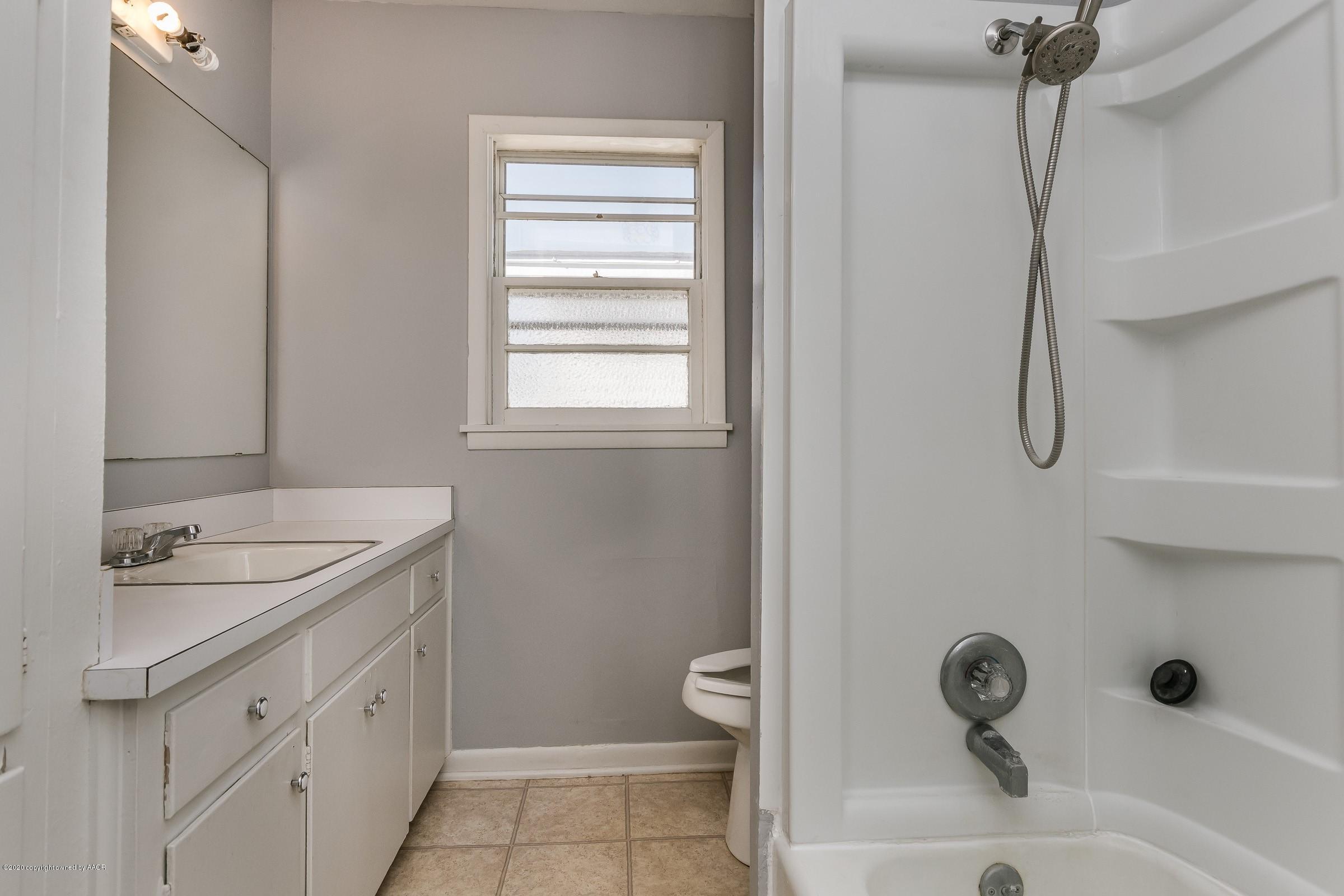 4200 South Bonham Street Amarillo, TX 79110 - Photo 12 of 20 a bathroom with a granite countertop sink a toilet and a mirror