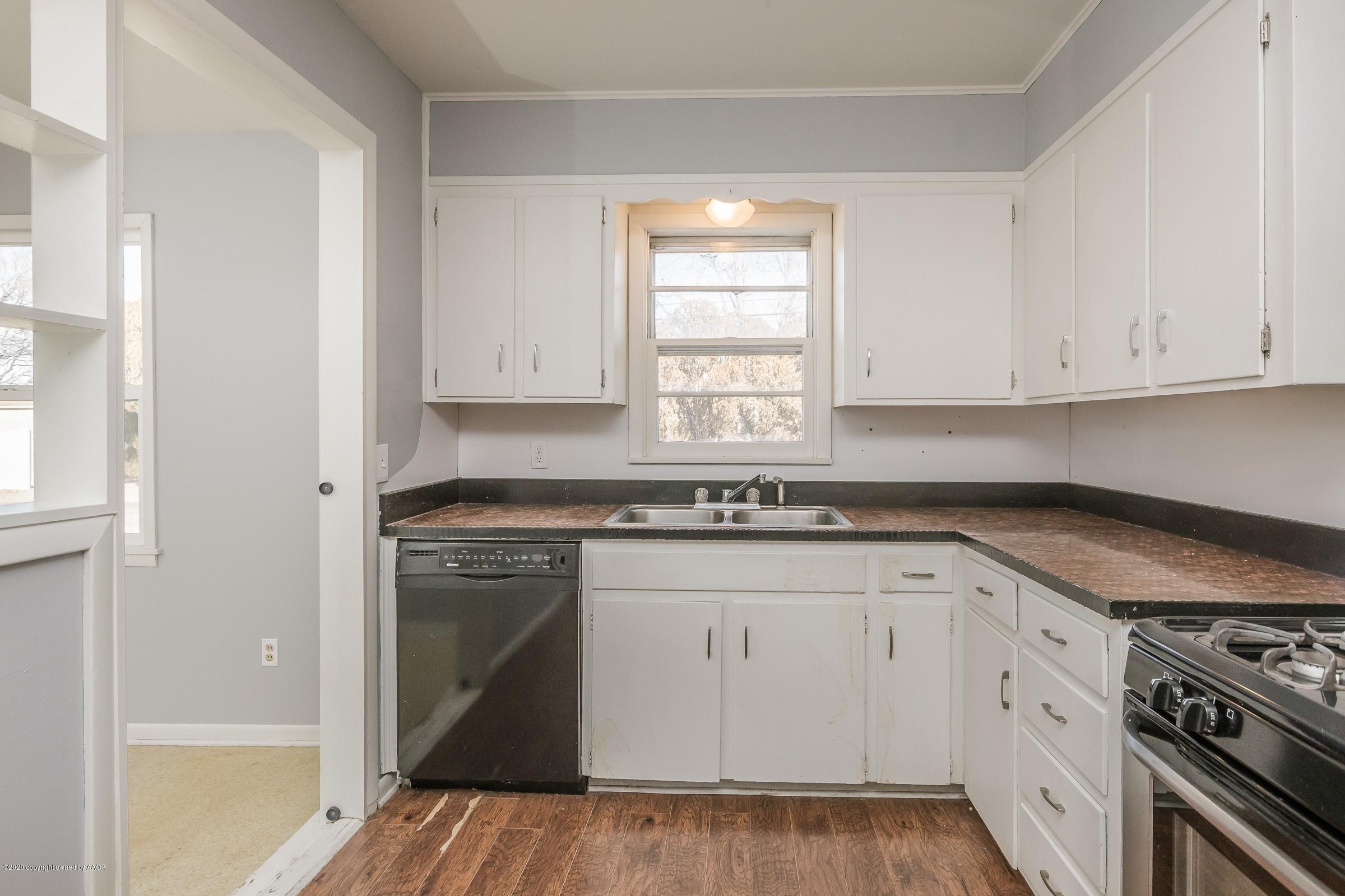 4200 South Bonham Street Amarillo, TX 79110 - Photo 7 of 20 a kitchen with granite countertop white cabinets and a stove