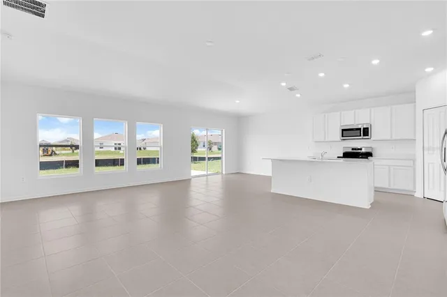 a view of kitchen with stainless steel appliances a refrigerator and a stove top oven