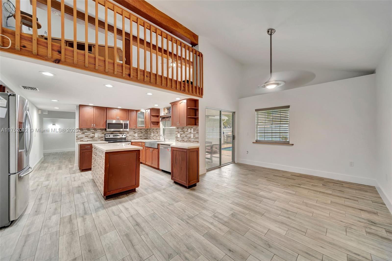 15006 Southwest 141st Court Miami, FL 33186 - Photo 11 of 27 a large kitchen with stainless steel appliances kitchen island granite countertop a sink a counter space and cabinets