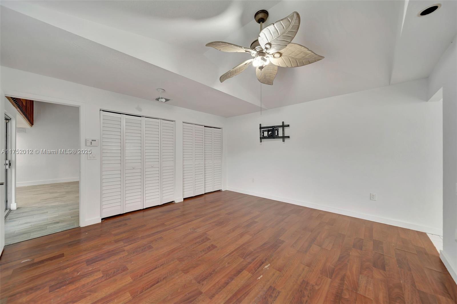15006 Southwest 141st Court Miami, FL 33186 - Photo 14 of 27 an empty room with wooden floor fan and windows