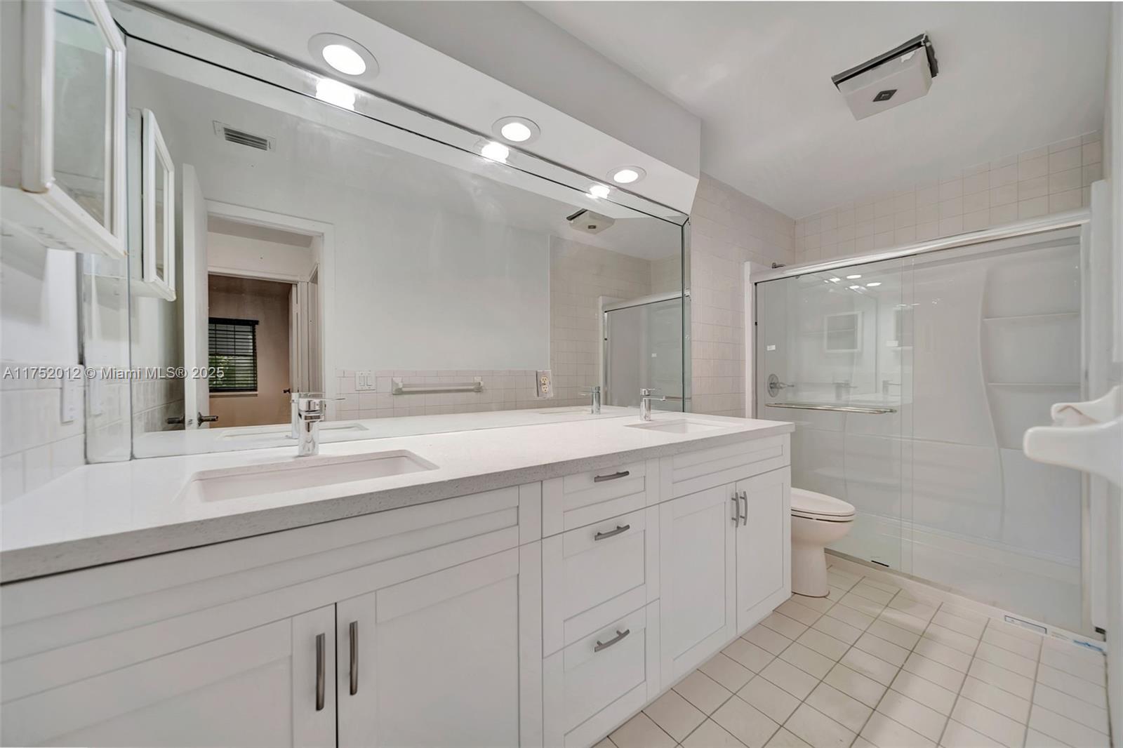15006 Southwest 141st Court Miami, FL 33186 - Photo 19 of 27 a bathroom with a double vanity sink toilet and a mirror
