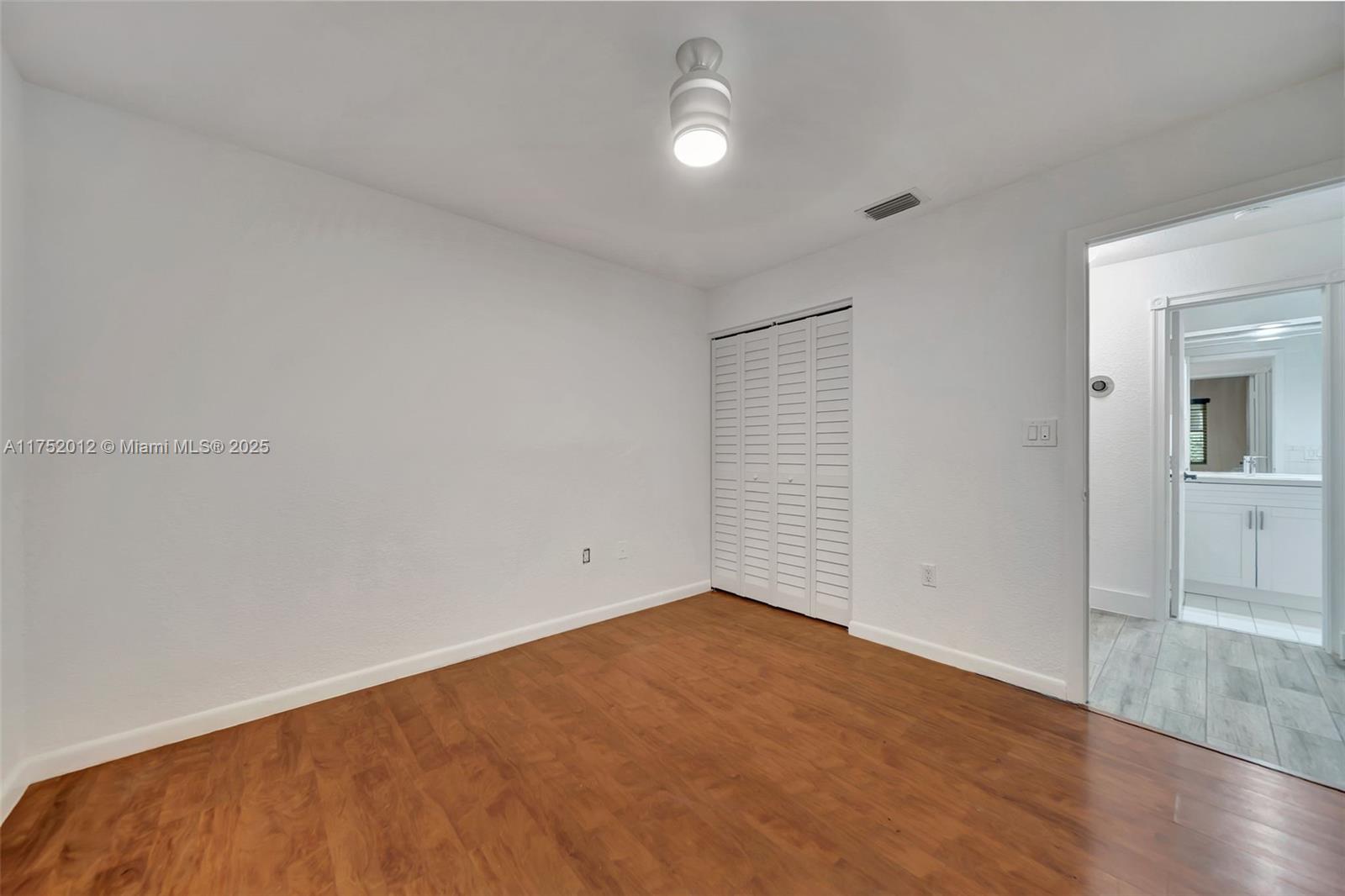 15006 Southwest 141st Court Miami, FL 33186 - Photo 21 of 27 an empty room with wooden floor and windows
