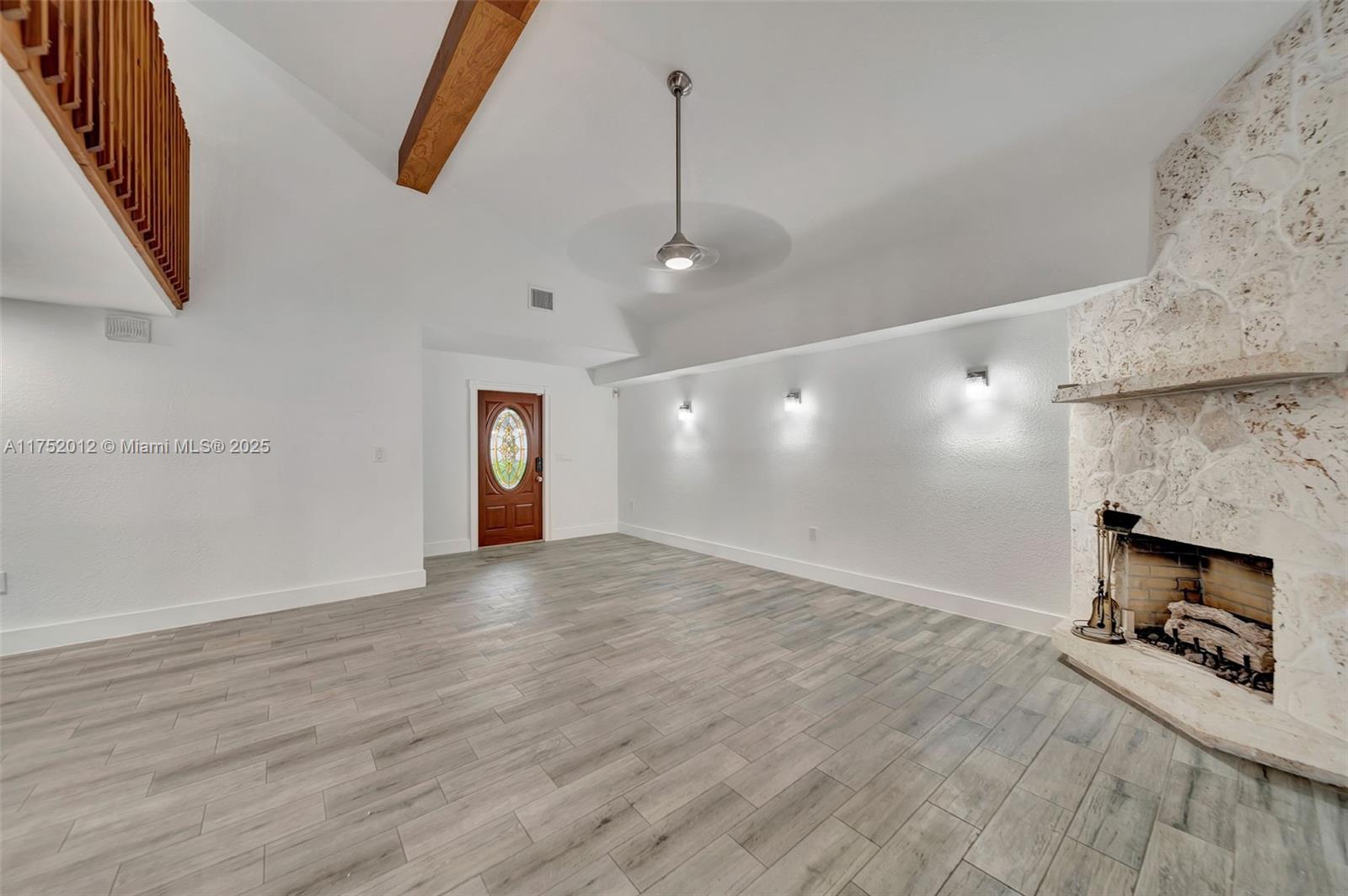 15006 Southwest 141st Court Miami, FL 33186 - Photo 3 of 27 an empty room with wooden floor and fireplace