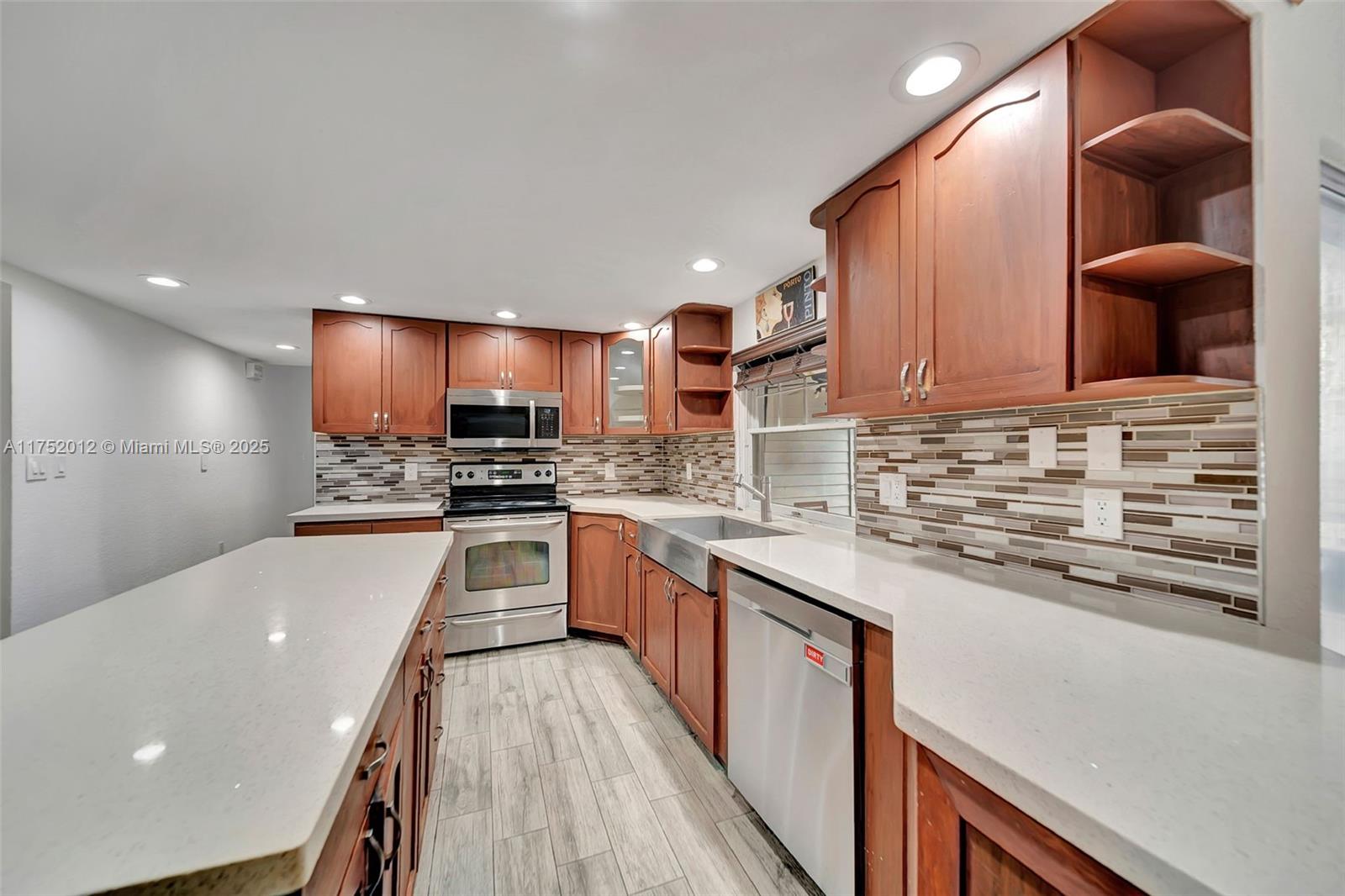 15006 Southwest 141st Court Miami, FL 33186 - Photo 9 of 27 a kitchen with stainless steel appliances granite countertop a sink and a stove