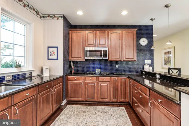 a kitchen with stainless steel appliances granite countertop a sink and a stove