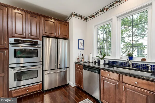 a kitchen with granite countertop stainless steel appliances a stove sink and microwave