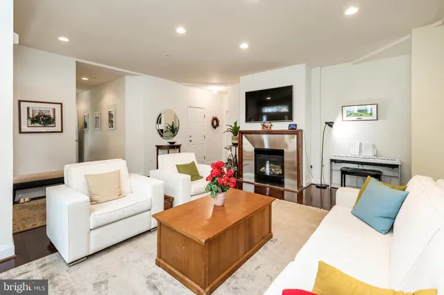 a living room with furniture a flat screen tv and a fireplace