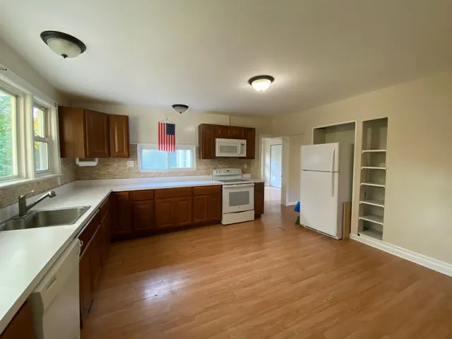 a large kitchen with a large counter top stainless steel appliances and cabinets