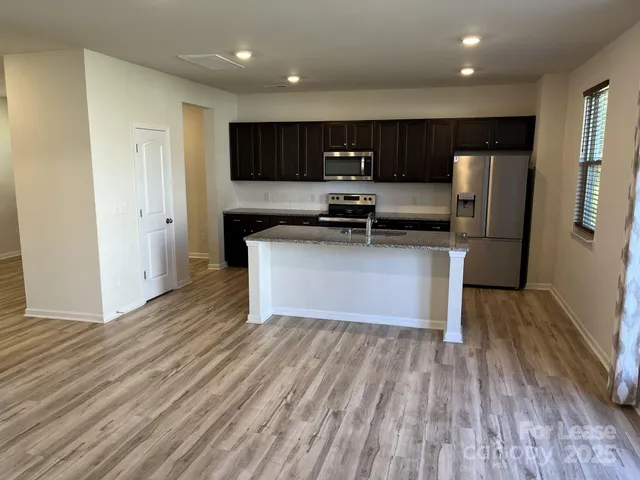 a kitchen with stainless steel appliances a refrigerator sink and microwave