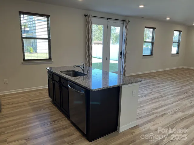 a kitchen with granite countertop a sink and a stove
