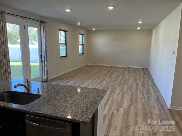 a view of a sink and dishwasher with wooden floor